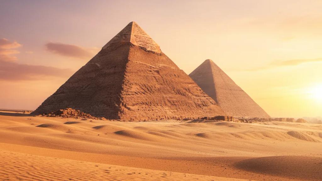 Traveler near the Giza pyramids at golden hour checking whether their phone has signal