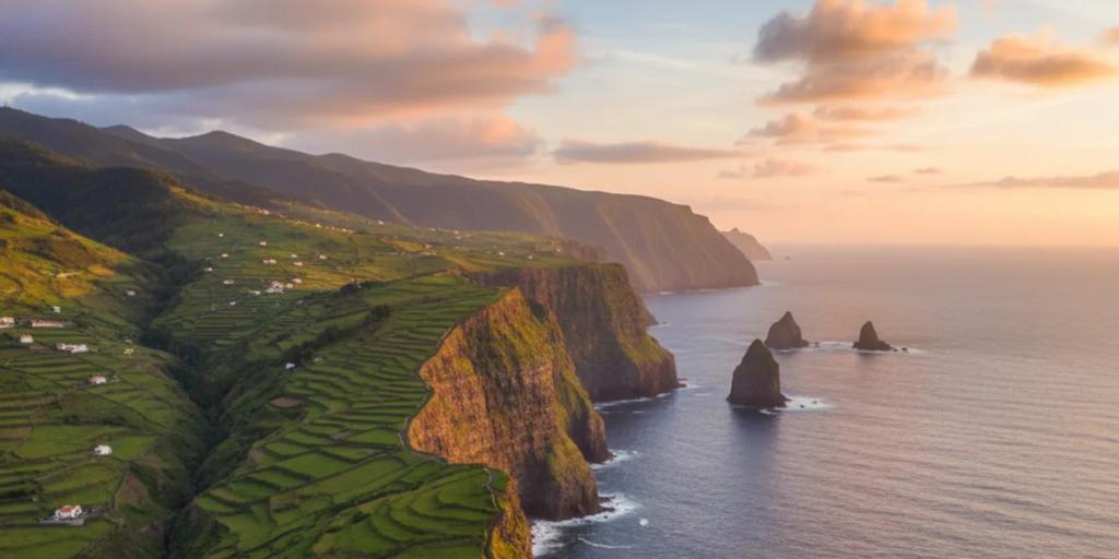 Een levada-pad dat zich langs groene kliffen hoog boven de Atlantische Oceaan slingert aan de noordkust van Madeira