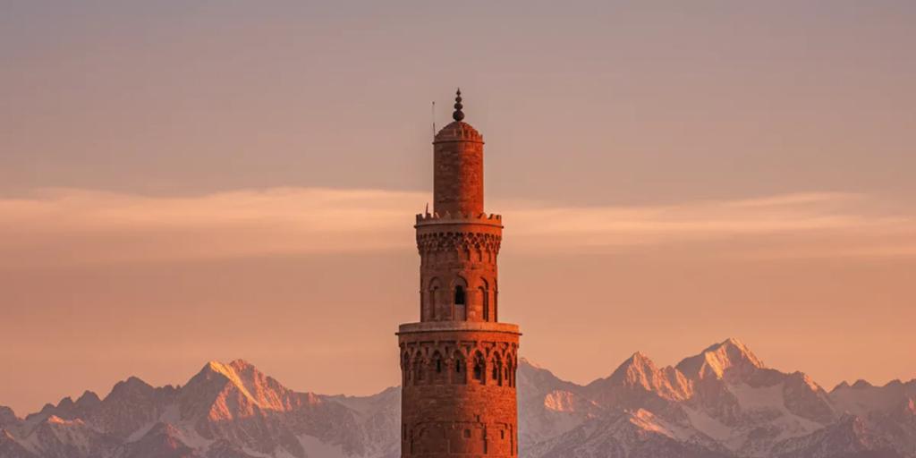 Marrakesh medina rooftops with the Koutoubia minaret and the snow-dusted Atlas mountains beyond
