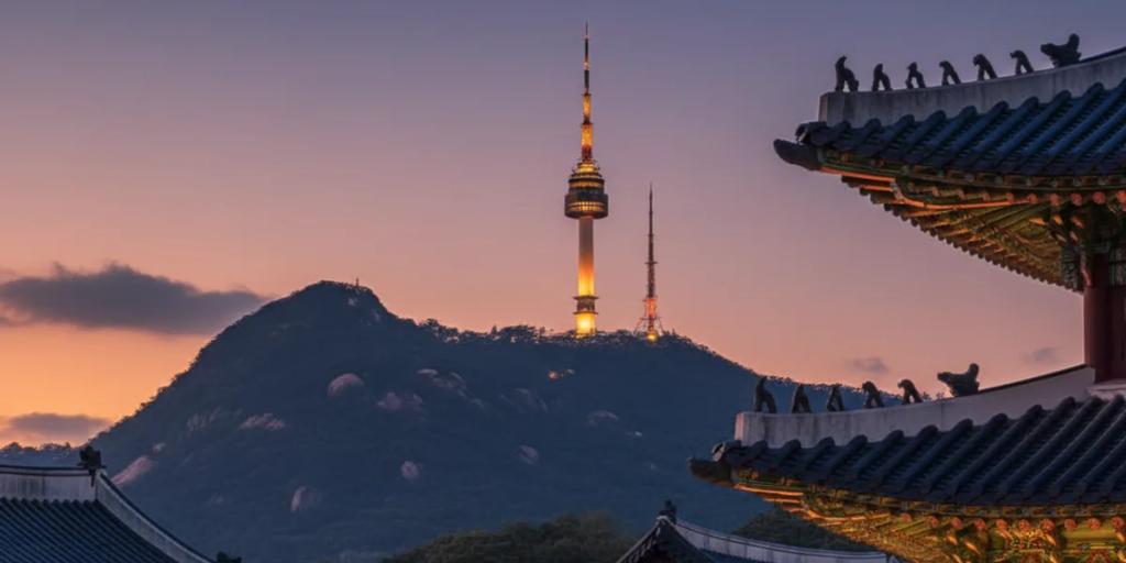 Gyeongbokgung palace rooflines in the foreground with N Seoul Tower rising on Namsan behind