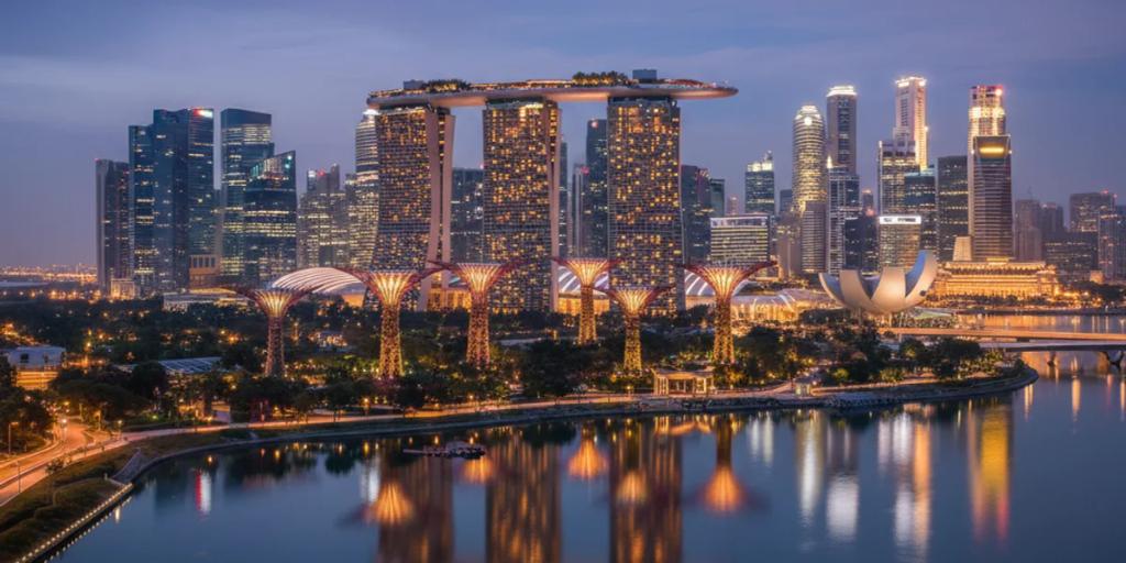 Marina Bay skyline and the Supertrees of Gardens by the Bay glowing at blue hour