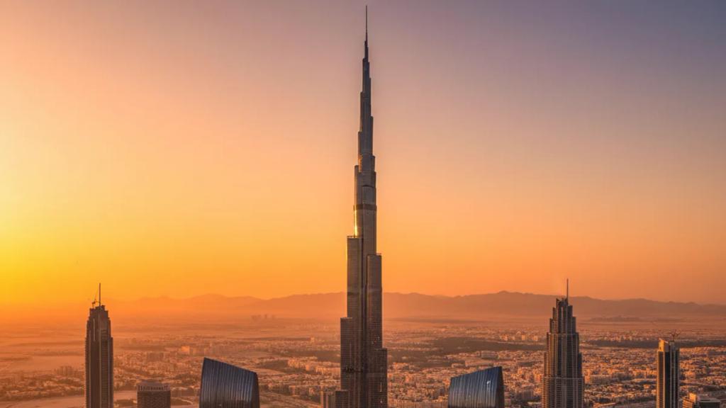 Traveler by the Dubai skyline at dusk checking a phone showing a connected mobile signal