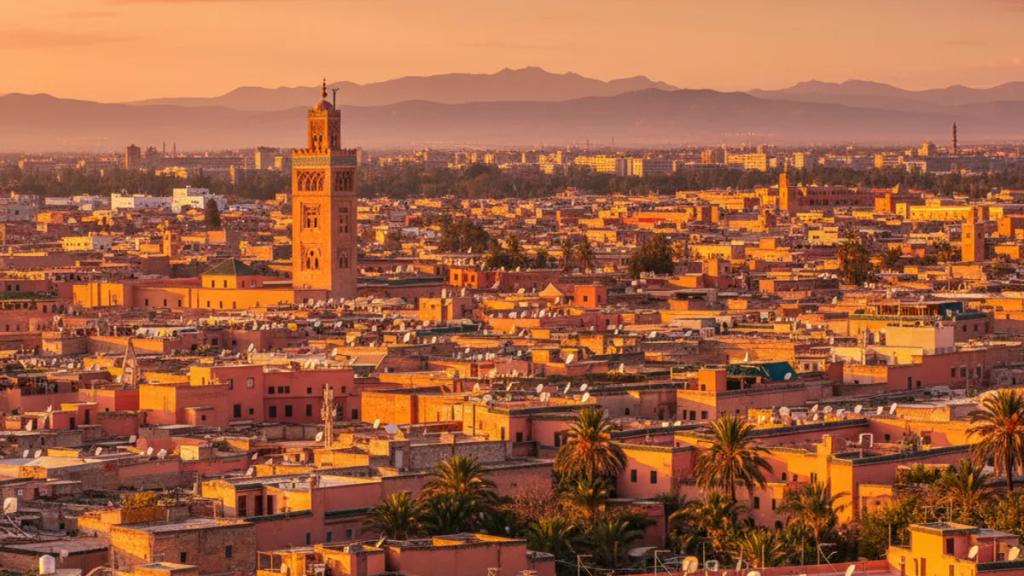 UK traveler in a Marrakech medina at golden hour checking a phone showing a connected mobile signal