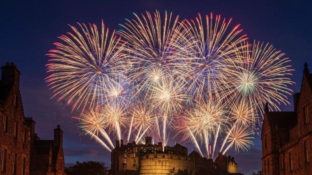 Midnight fireworks bursting over Edinburgh Castle above a packed Princes Street during Hogmanay